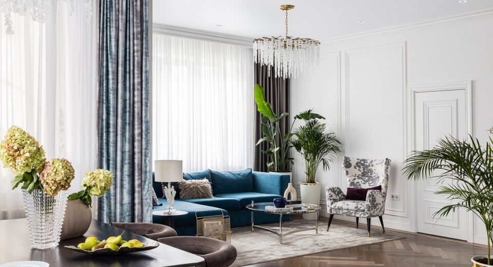A living room with blue furniture and a chandelier.