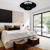 A bedroom with a large bed and a sliding glass door.