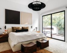 A bedroom with a large bed and a sliding glass door.