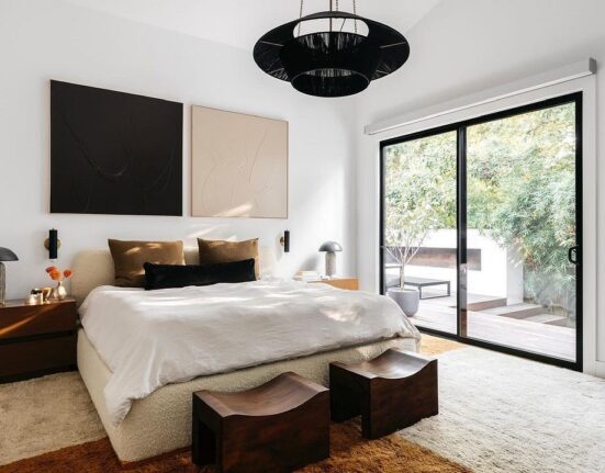 A bedroom with a large bed and a sliding glass door.