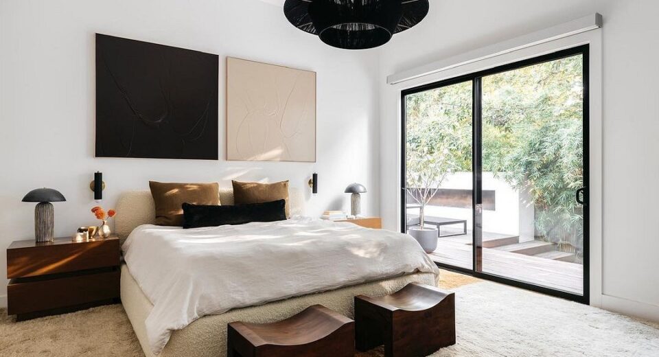 A bedroom with a large bed and a sliding glass door.