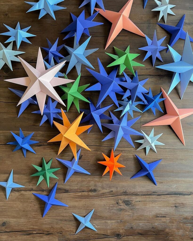 A group of paper stars arranged on a wooden table.