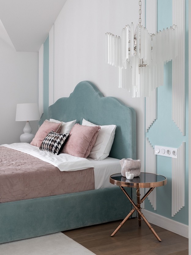 A blue and white bedroom with a chandelier.