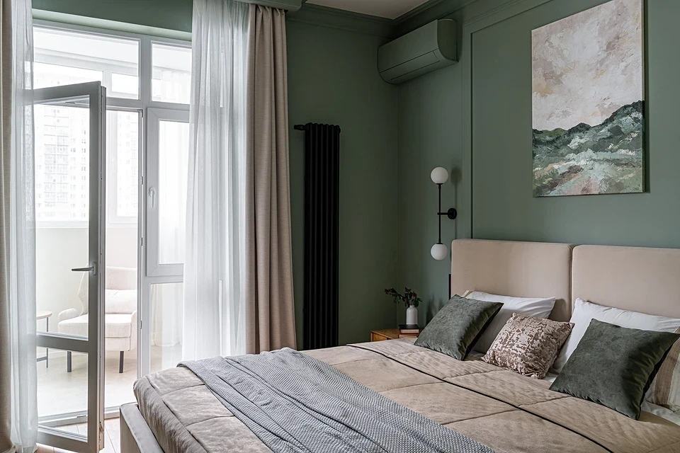 A bedroom with green walls and a white bed.