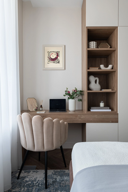 A bedroom with a desk, chair and bookshelves.