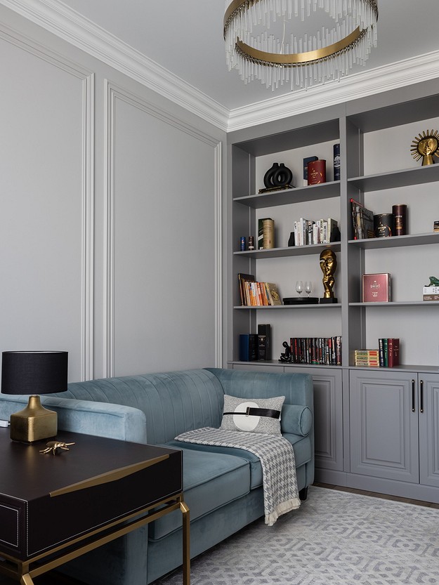 A living room with a blue couch and bookshelves.