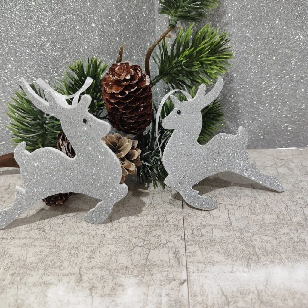 Two silver reindeer ornaments on a table.