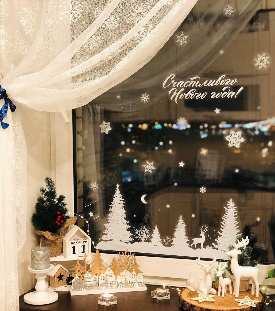 A window decorated with christmas trees and snowflakes.