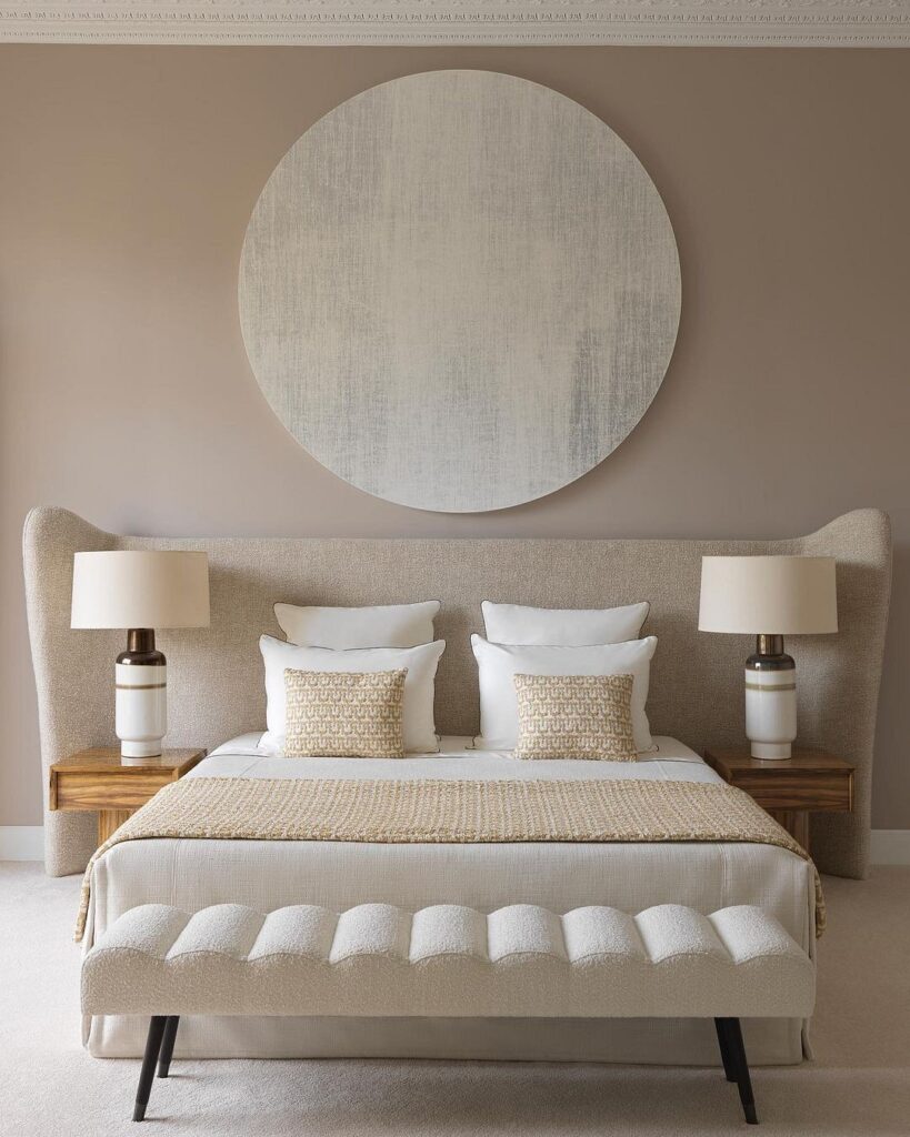 A bedroom with beige walls and a large round bed.