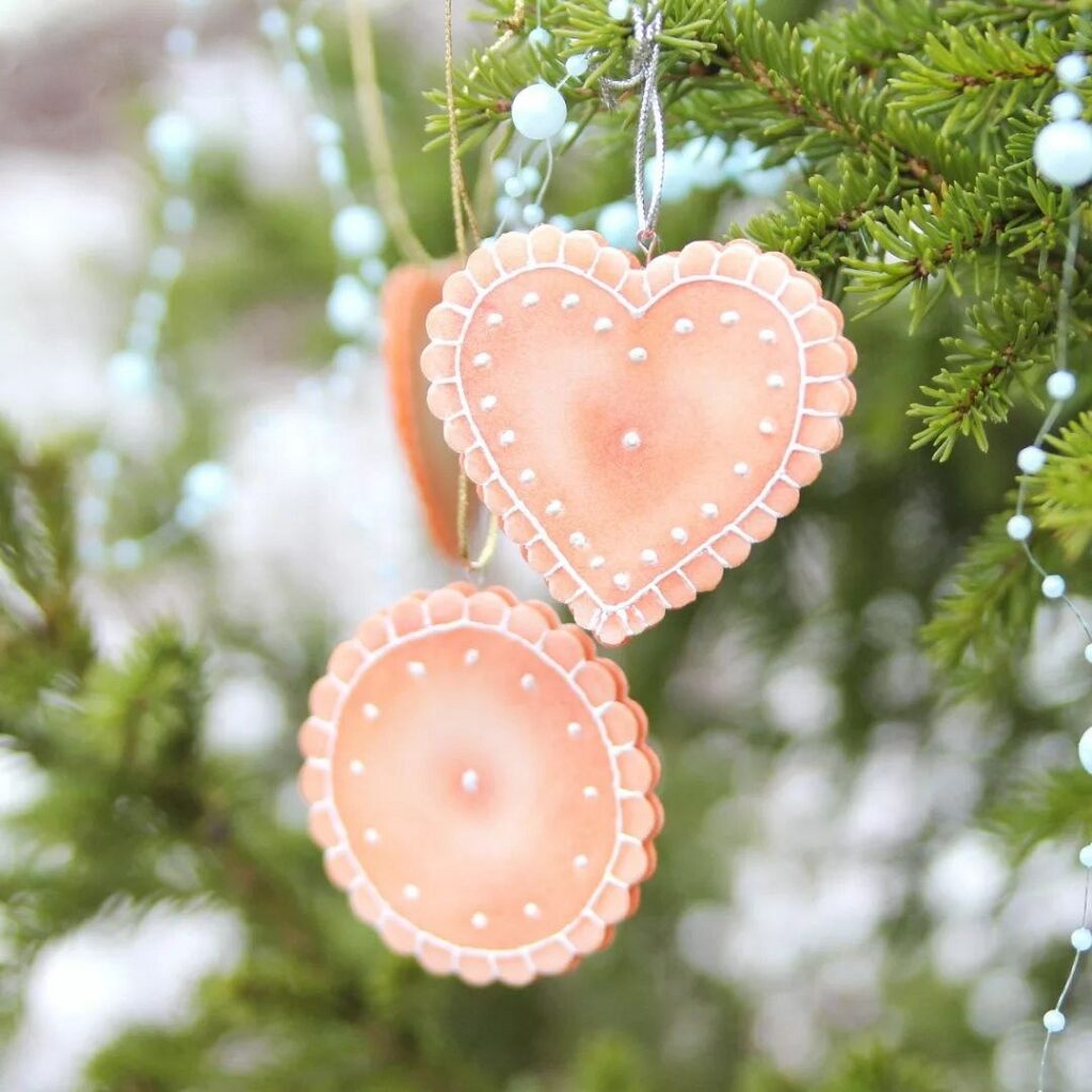 Gingerbread ornaments hanging from a christmas tree.