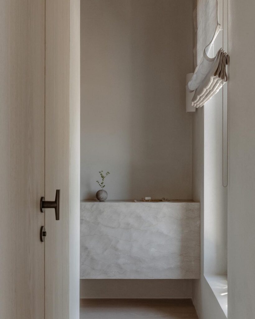 A bathroom with white walls and a wooden door.