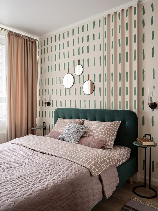 A pink and green bedroom with polka dot wallpaper.