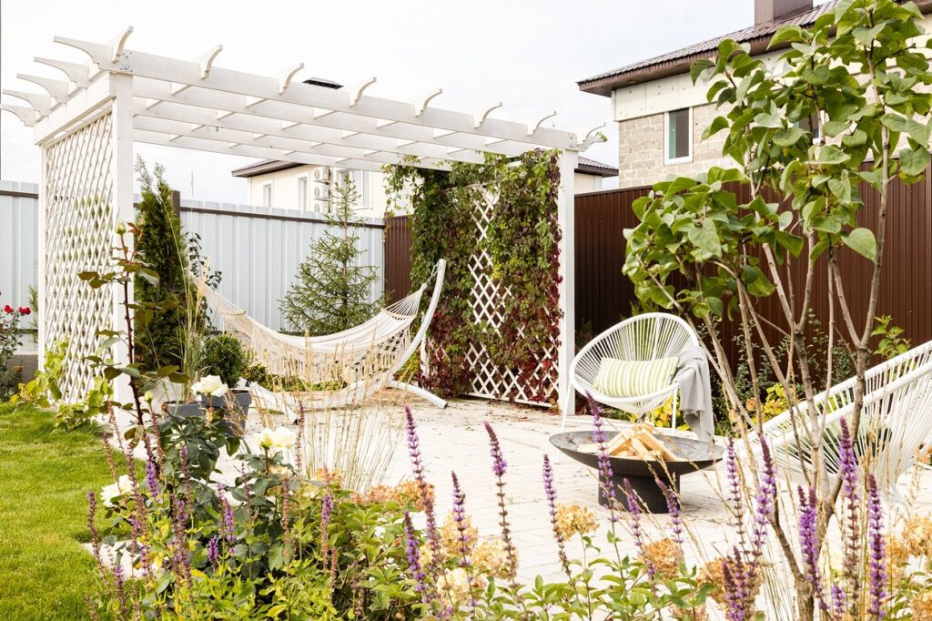 A backyard with a hammock and fire pit.