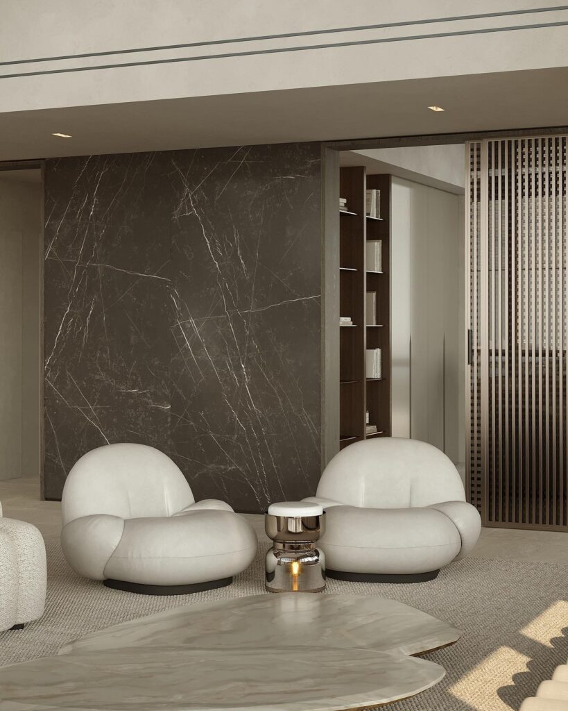 A living room with white furniture and a marble wall.