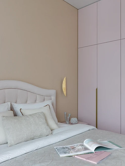 A bedroom with pink walls and a white bed.