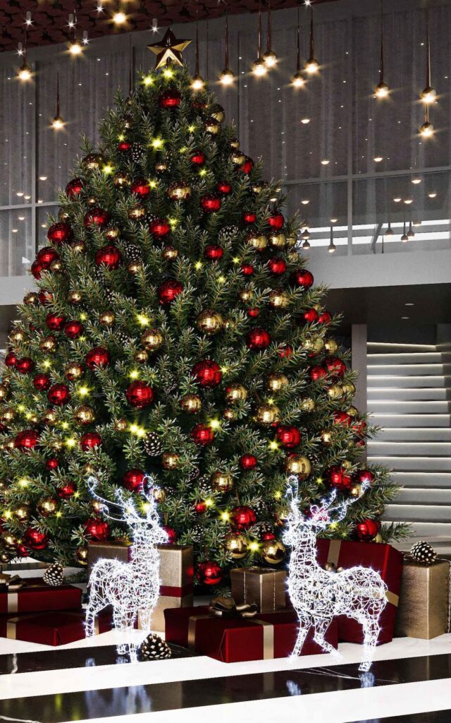 A christmas tree in a lobby with reindeer statues.