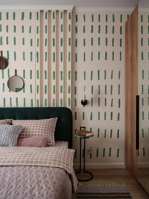 A bedroom with green and pink stripes on the walls.