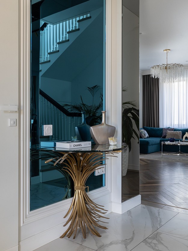 A living room with a glass door and a gold table.