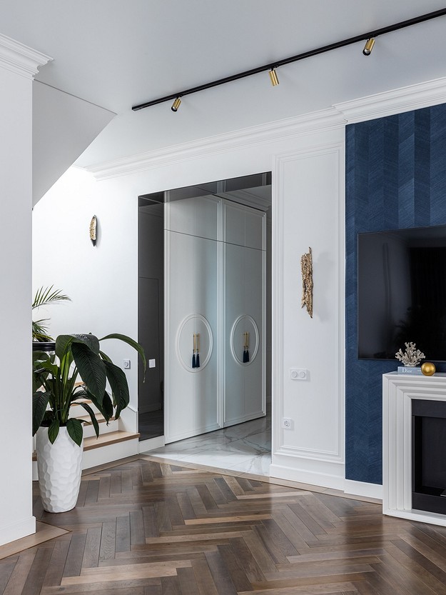 A living room with blue walls and wood floors.