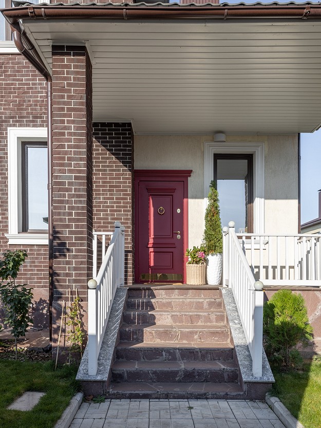 A house with a red door and steps leading up to it.