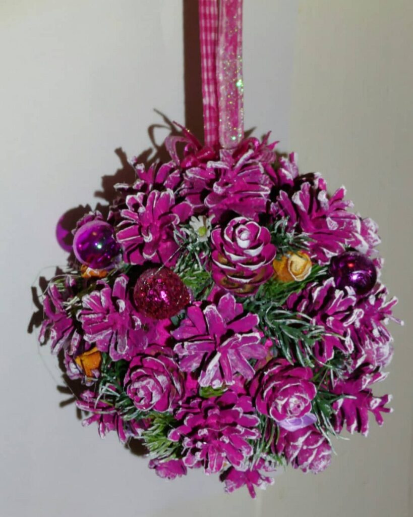 A purple flower ball hanging on a wall.