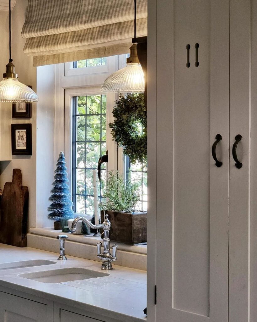 A kitchen with white cabinets and a window.