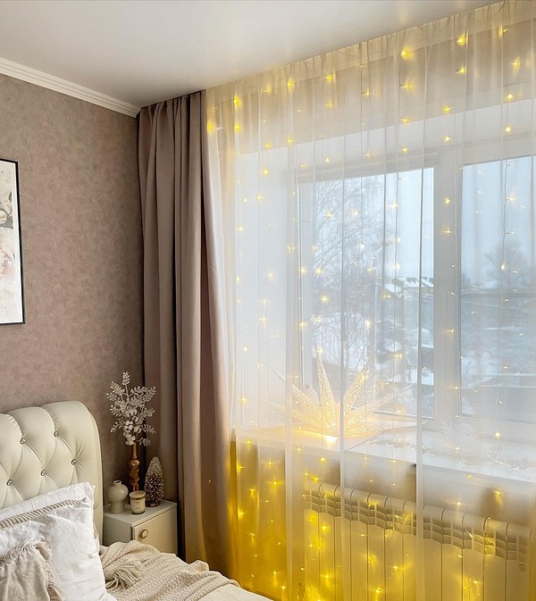 A bedroom with a bed and yellow curtains.