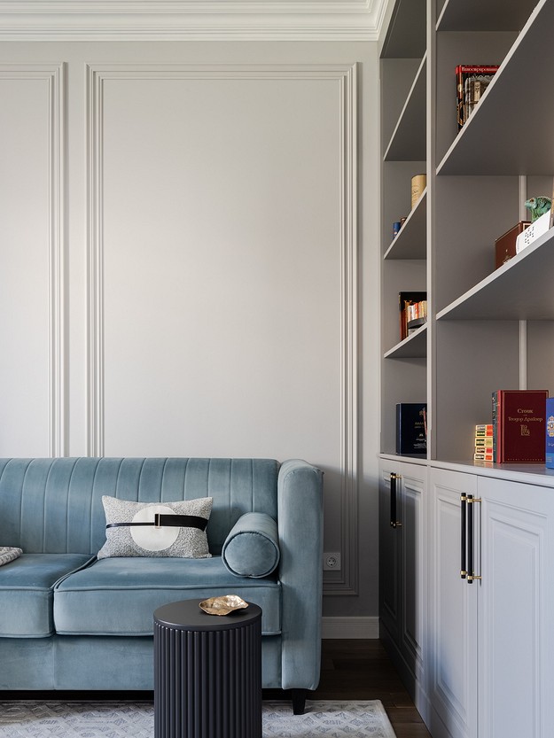 A living room with a blue sofa and bookshelves.