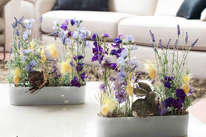 Two vases filled with flowers on a coffee table.