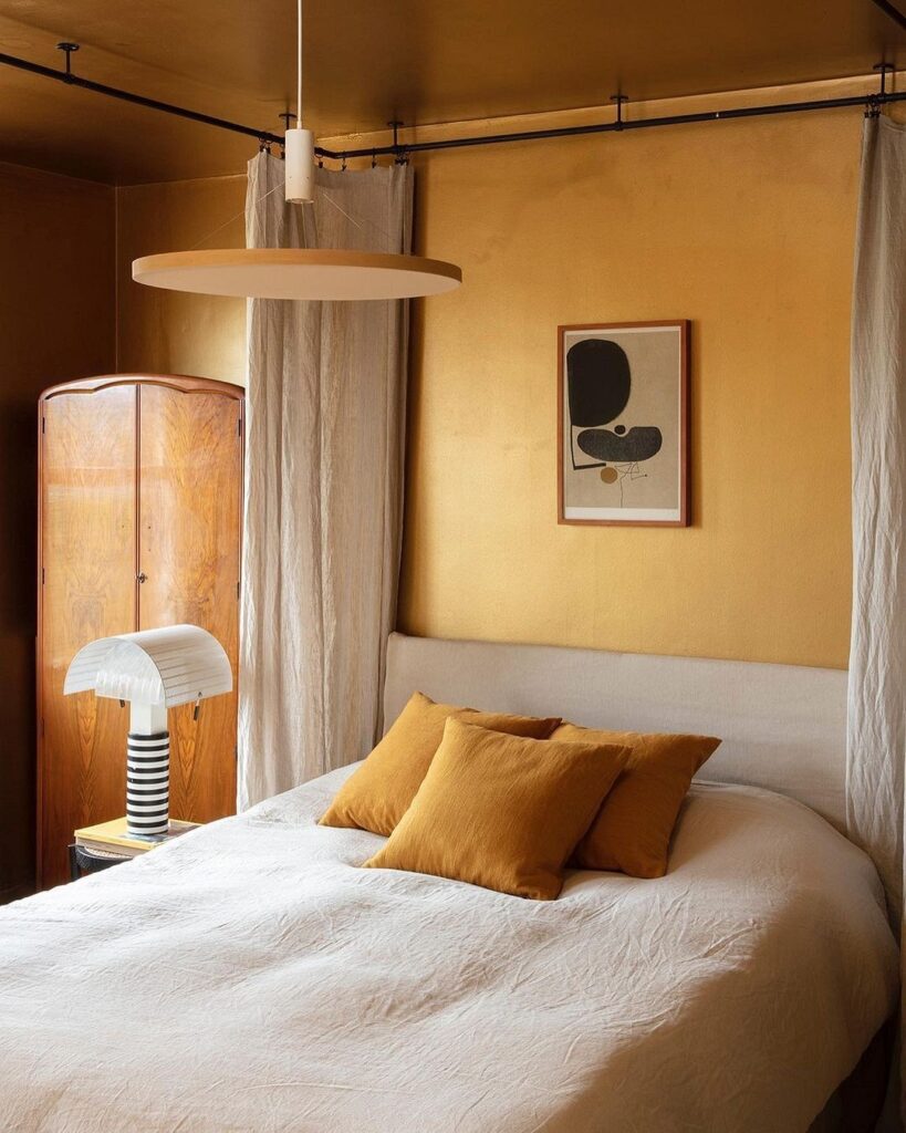 A bedroom with yellow walls and a bed.