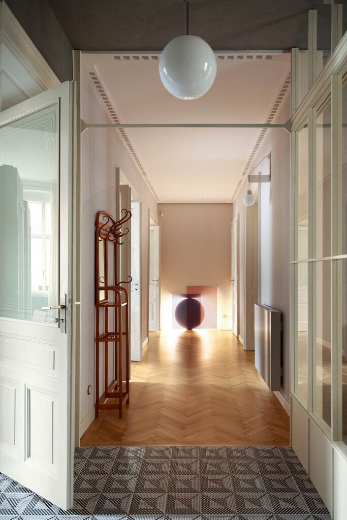A hallway with a wooden floor and a glass door.