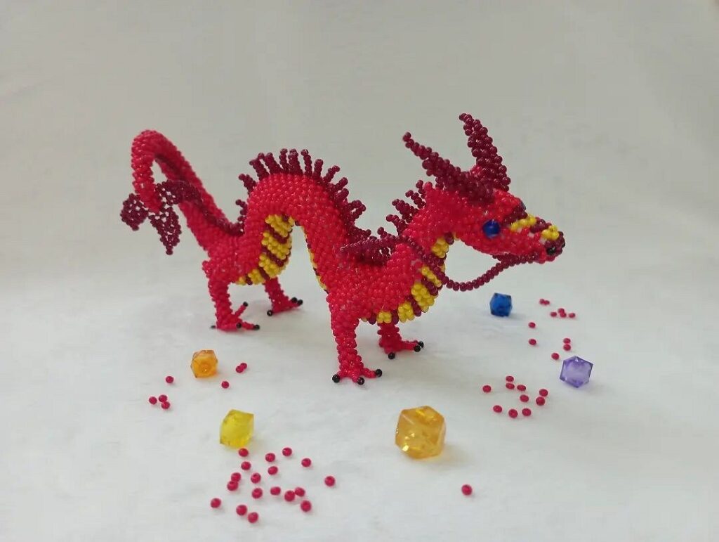 A red dragon made of beads and crystals.