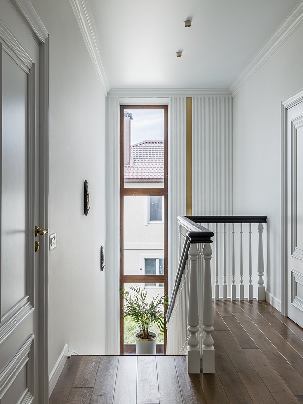 A hallway with white walls and wooden floors.