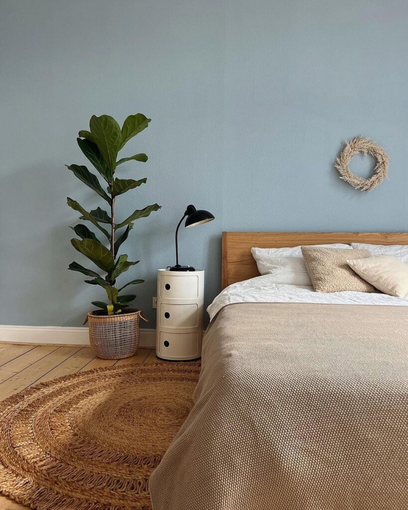 A bedroom with blue walls and a wooden bed.