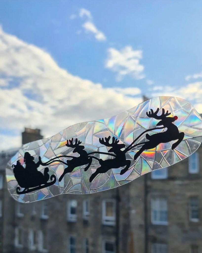 A window sticker with santa claus on a sleigh.