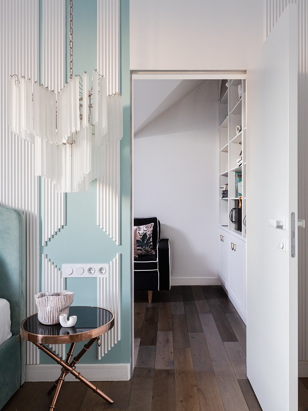 A bedroom with blue and white walls and a chandelier.