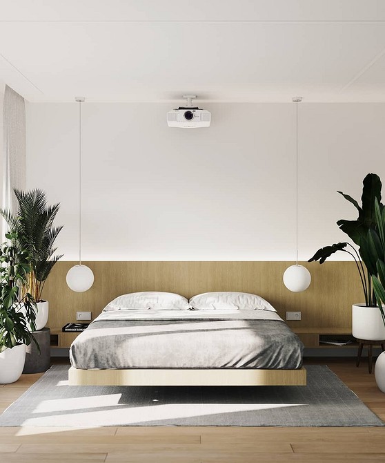 A modern bedroom with a bed and plants.