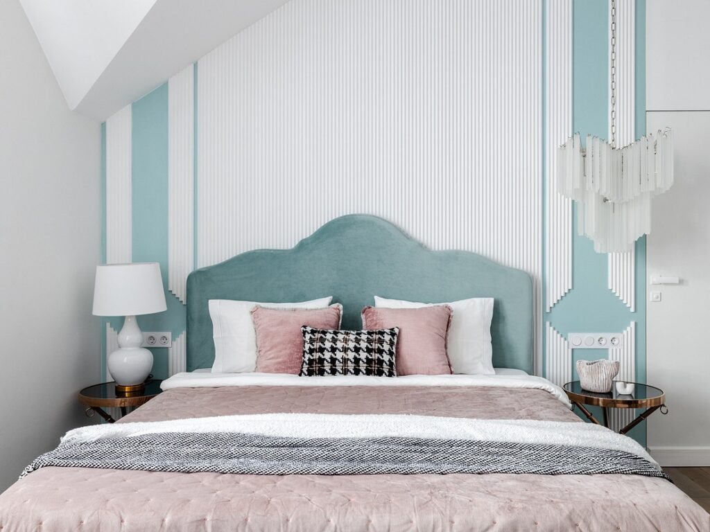 A pink and white bedroom with a blue headboard.