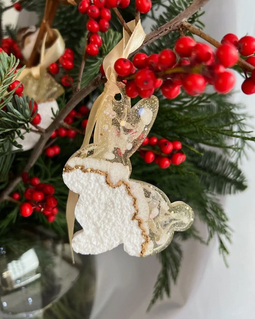 A christmas tree with a white bunny ornament and red berries.