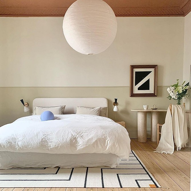 A white bed in a bedroom with wooden floors.