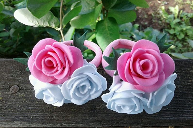 Two pink and white roses on a wooden bench.