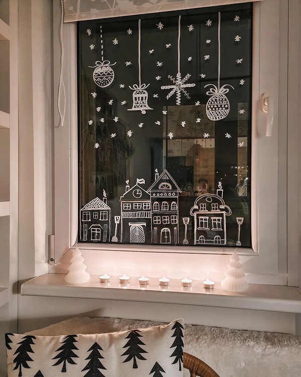 A christmas window display with a candle and a christmas tree.