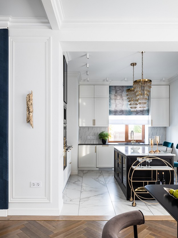 A modern kitchen with blue walls and wooden floors.