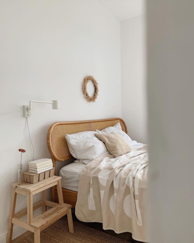 A bedroom with white walls and a wooden bed.