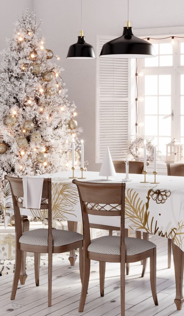 A white and gold christmas dining room with a christmas tree.