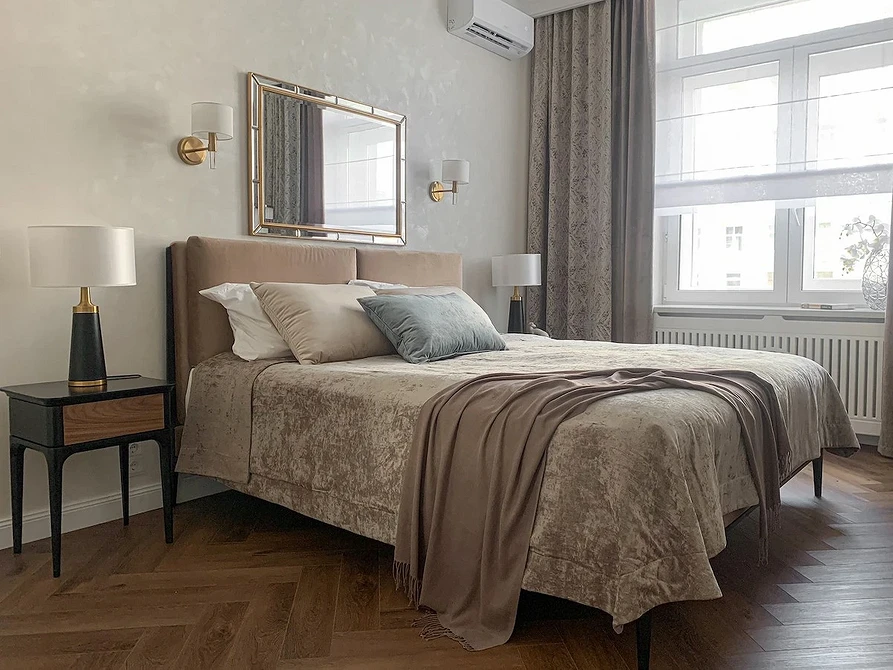 A bedroom with beige walls and wooden floors.