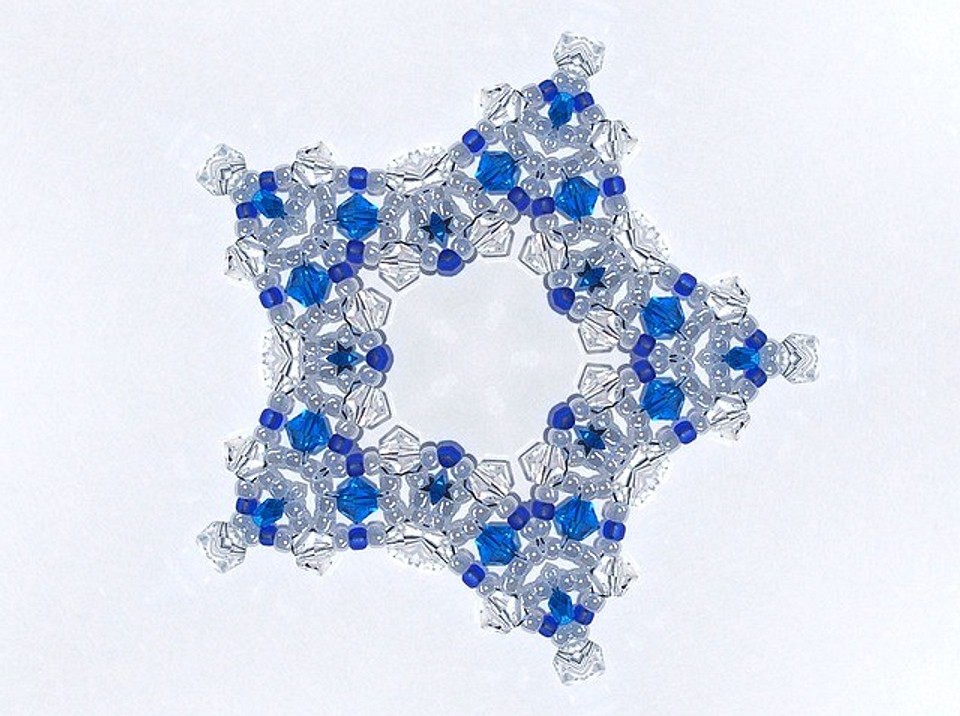 A blue and white snowflake on a white surface.