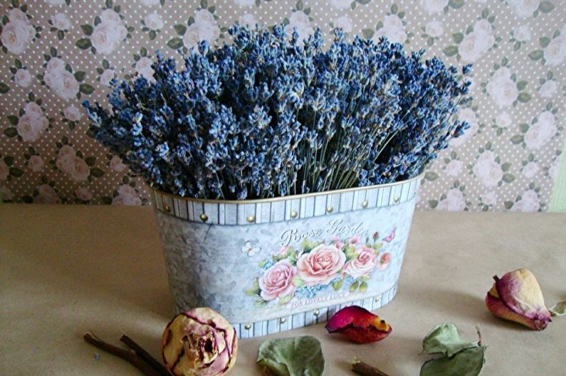 Lavender flowers in a tin container on a table.