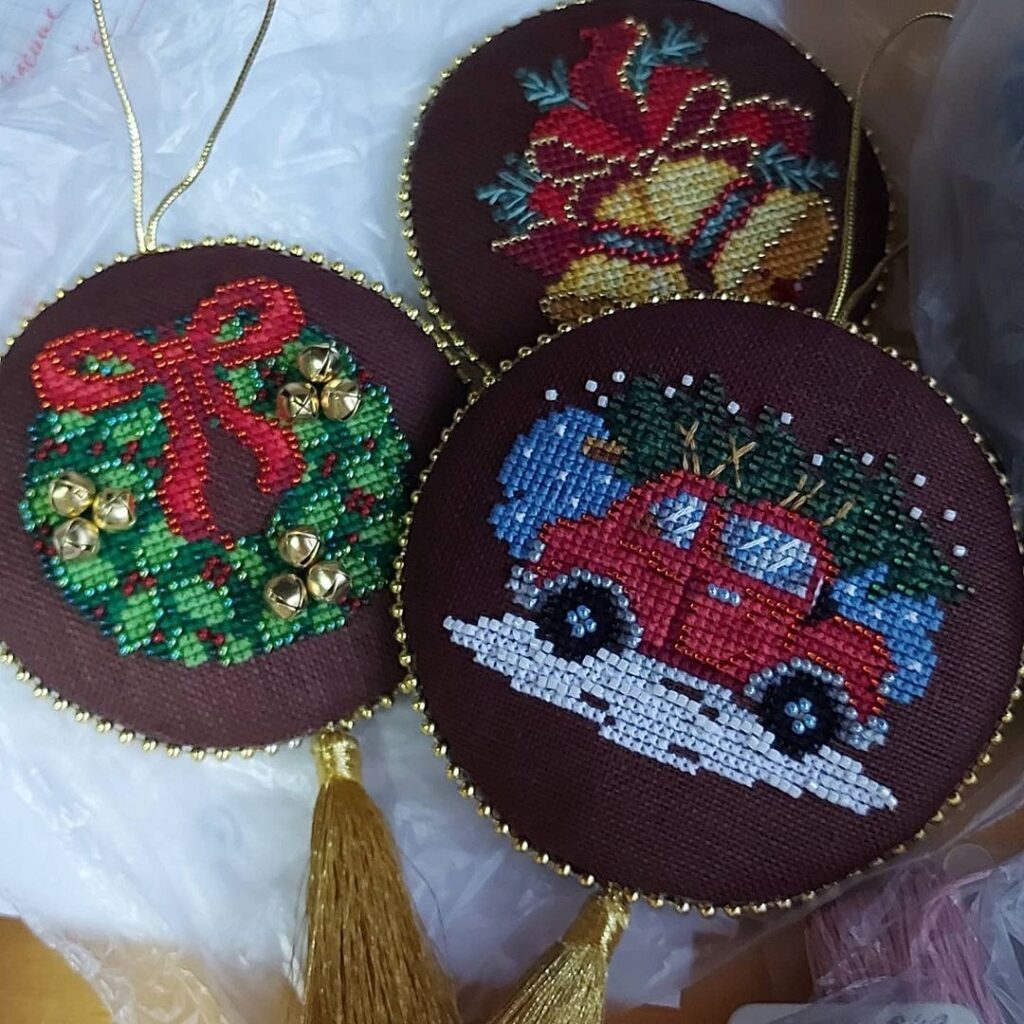 Three christmas ornaments are sitting on a table.