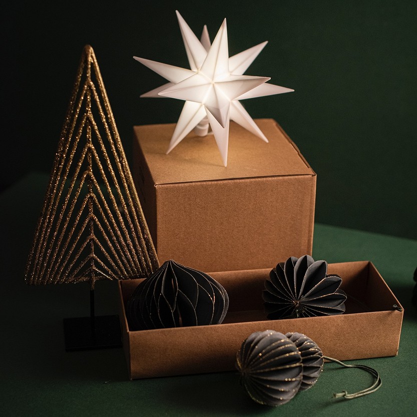 A christmas tree and ornaments in a cardboard box.